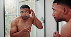 Man, mirror and skincare with acne in bathroom for hygiene, dermatology or pimple in home. Male person, stress and skin breakout with reflection or anxiety for beauty, bacteria or pore in house