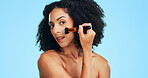 Portrait, makeup and woman with brush in studio for cosmetics, application and makeover. Cosmetology, space and person with tools for powder, beauty products and salon aesthetic on blue background