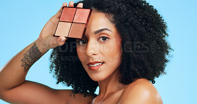Buy stock photo Portrait, woman and makeup palette in studio with foundation, blush and powder for beauty aesthetic. Confident, African person and cosmetic product for eyeshadow, glow and shine on blue background.