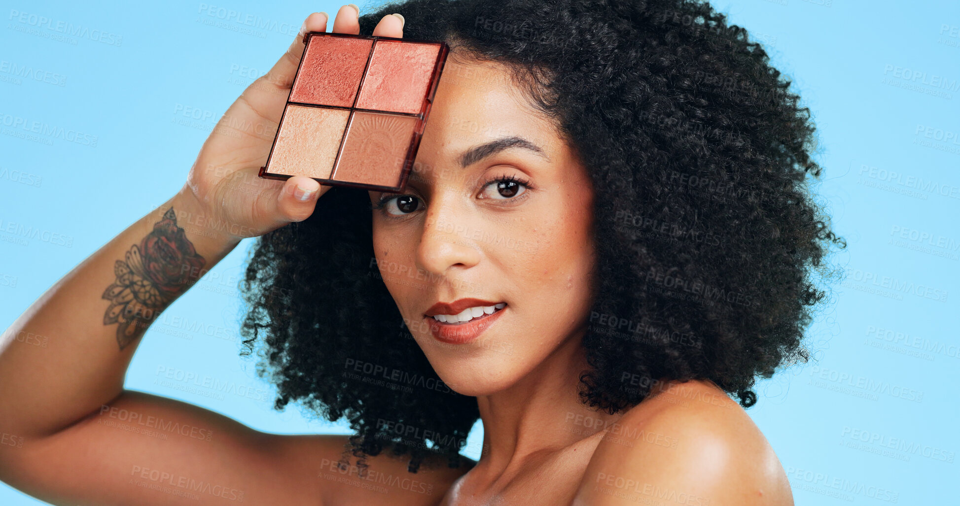 Buy stock photo Portrait, woman and makeup palette in studio with foundation, blush and powder for beauty aesthetic. Confident, African person and cosmetic product for eyeshadow, glow and shine on blue background.