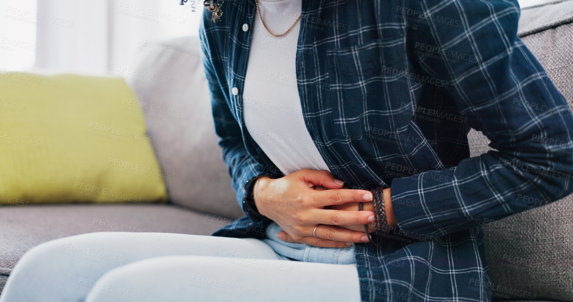 Buy stock photo Woman, hands and sofa with stomach ache in home for menstruation, pain or period cramps. Female person, sore belly and indigestion with gastrointestinal reflux or discomfort for IBS or constipation