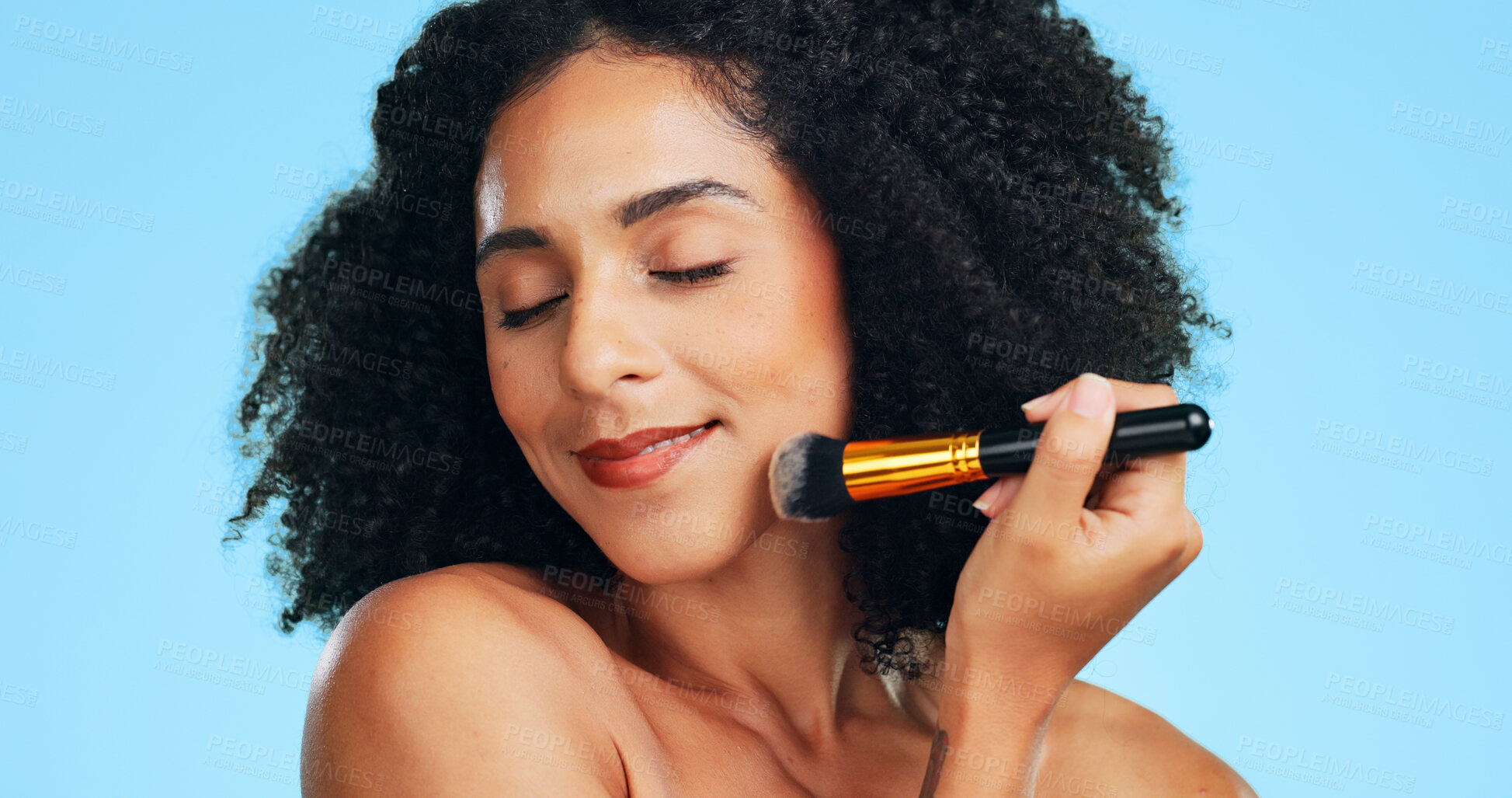 Buy stock photo Makeup, smile or woman in studio with brush, coverage or blending in beauty routine. Cosmetology, happy or female person on blue background with tools, makeover or flawless application for glow.