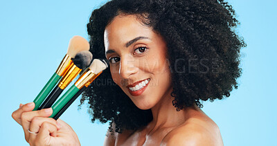 Buy stock photo Makeup, portrait or woman in studio with brushes, coverage or blending in beauty routine. Cosmetology, happy or female person on blue background with tools, makeover or flawless application for glow.