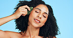 Woman, skincare or gua sha in studio with massage, beauty cosmetics or lymphatic drainage benefits. Person, relax and facial product for blood flow, dermatology or grooming routine on blue background