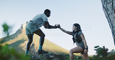Buy stock photo People, helping hand and hiking on mountain for outdoor adventure, journey or assistance in nature. Interracial couple, hikers or lift with partner for fitness, support or trekking on rock or cliff