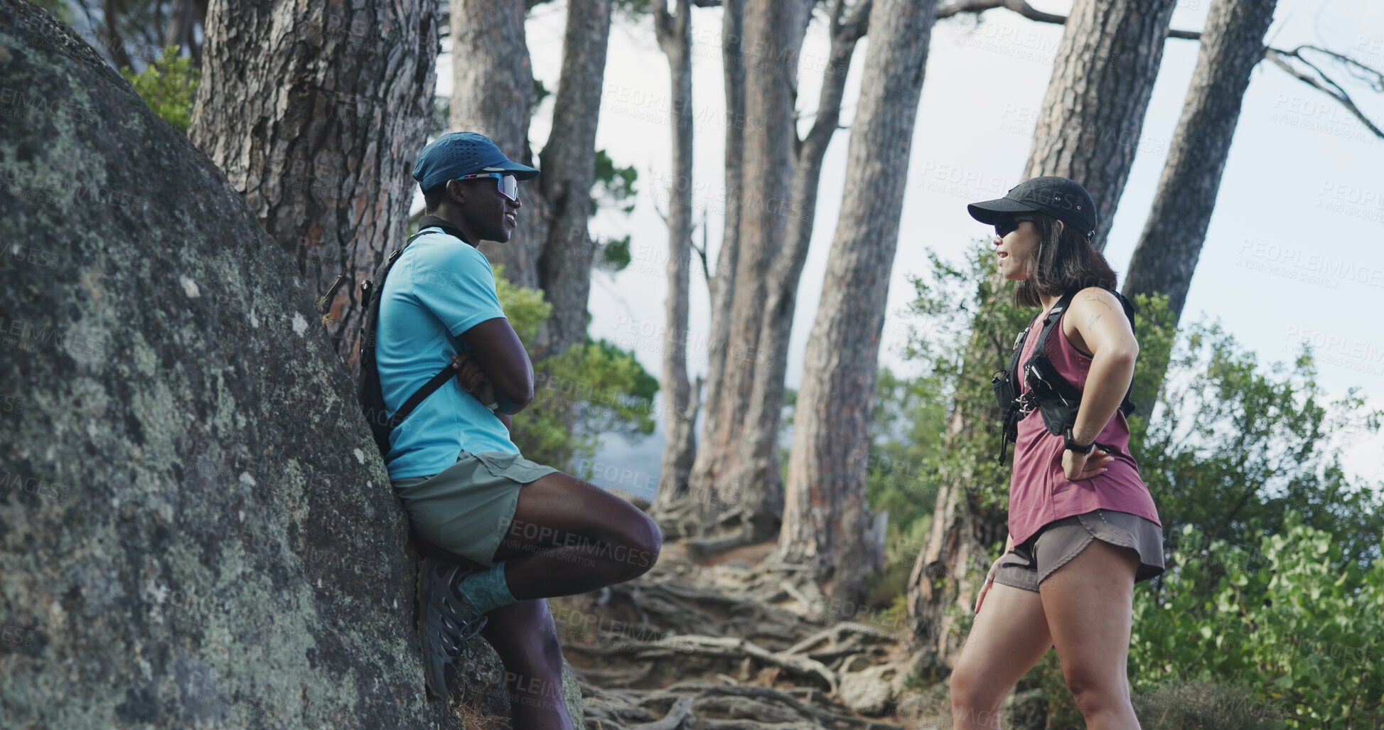 Buy stock photo Break, hiking and interracial couple with chat for fitness, trekking or adventure on mountain trail. Outdoor, hiker or people with conversation for travel, exercise rest or holiday and explore nature
