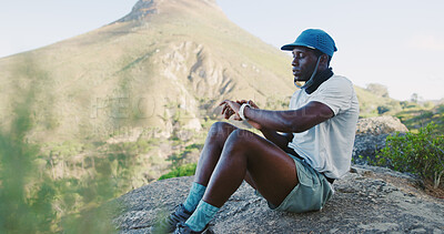 Buy stock photo Break, smart watch and black man on mountain for hiking, exercise or health in nature for fitness. Fatigue, accessory and African person with rest for trekking outdoor with challenge and wellness.