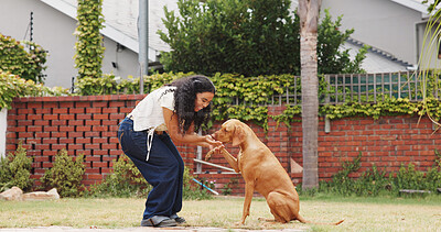 Buy stock photo Woman, feed and dog training in backyard with smile, animal care or companion for bonding together. Happy, person and teaching trick in home garden with puppy, eat treats or reward for good behavior.