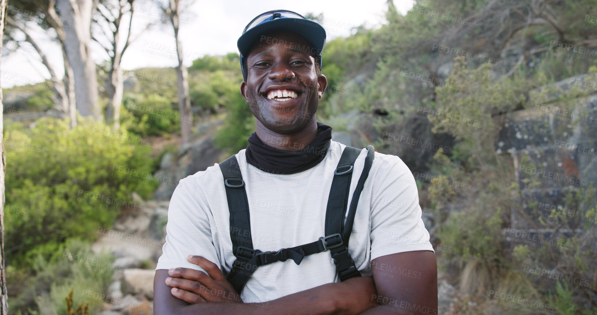 Buy stock photo Portrait, hiking and happy man with arms crossed in woods, outdoor and confident with hydration vest. Hiker, smile and black person with hobby in nature, travel and vacation for adventure in Kenya