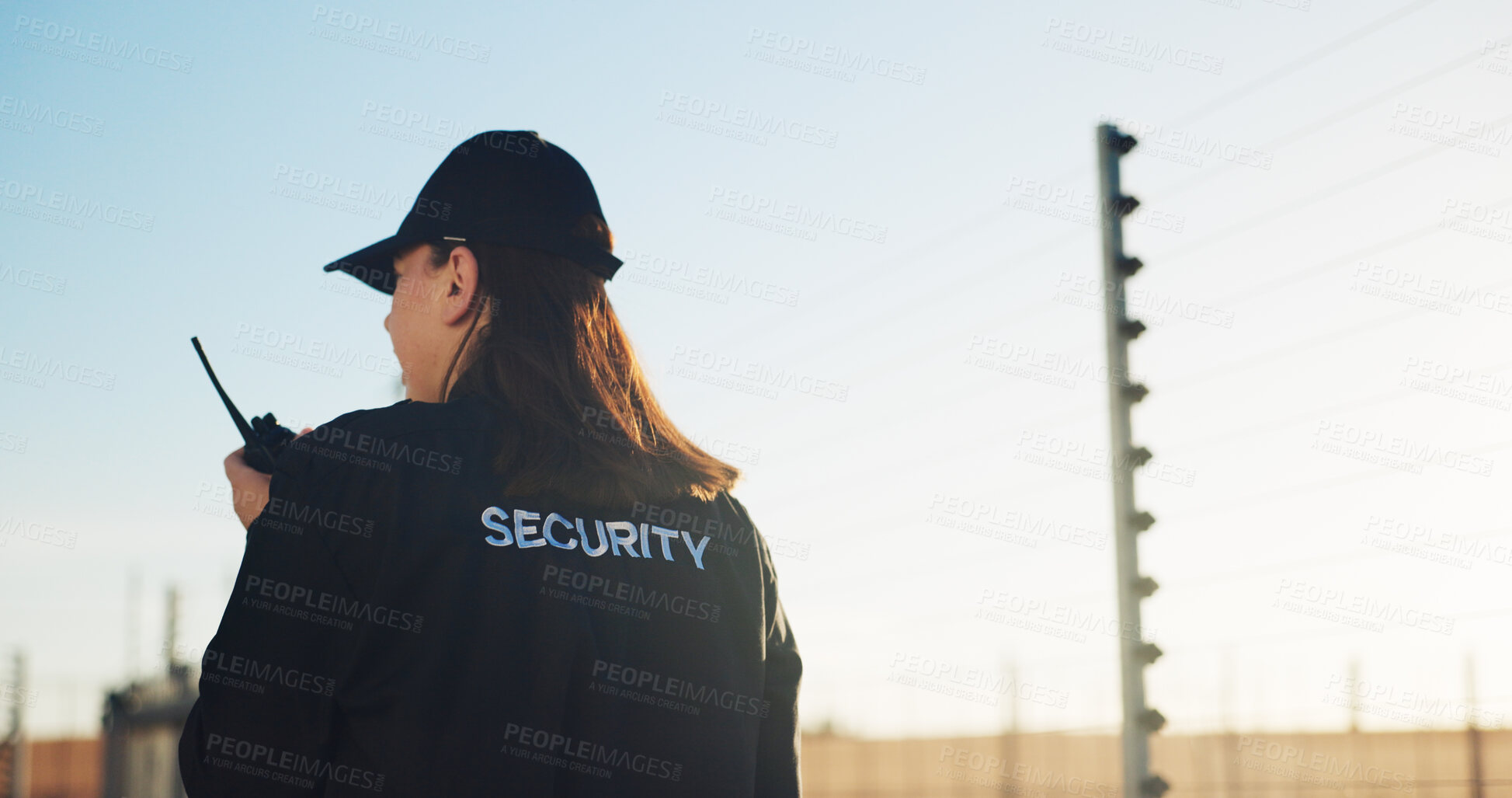 Buy stock photo Back, security and woman outdoor with radio for communication, surveillance and guard by fence. Protection, service and female person with tech for safety, perimeter search or patrol in nature