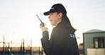 Conversation, security and woman outdoor with radio for communication, sunset surveillance and guard. Protection, service and person with tech for safety, perimeter search or patrol in property space