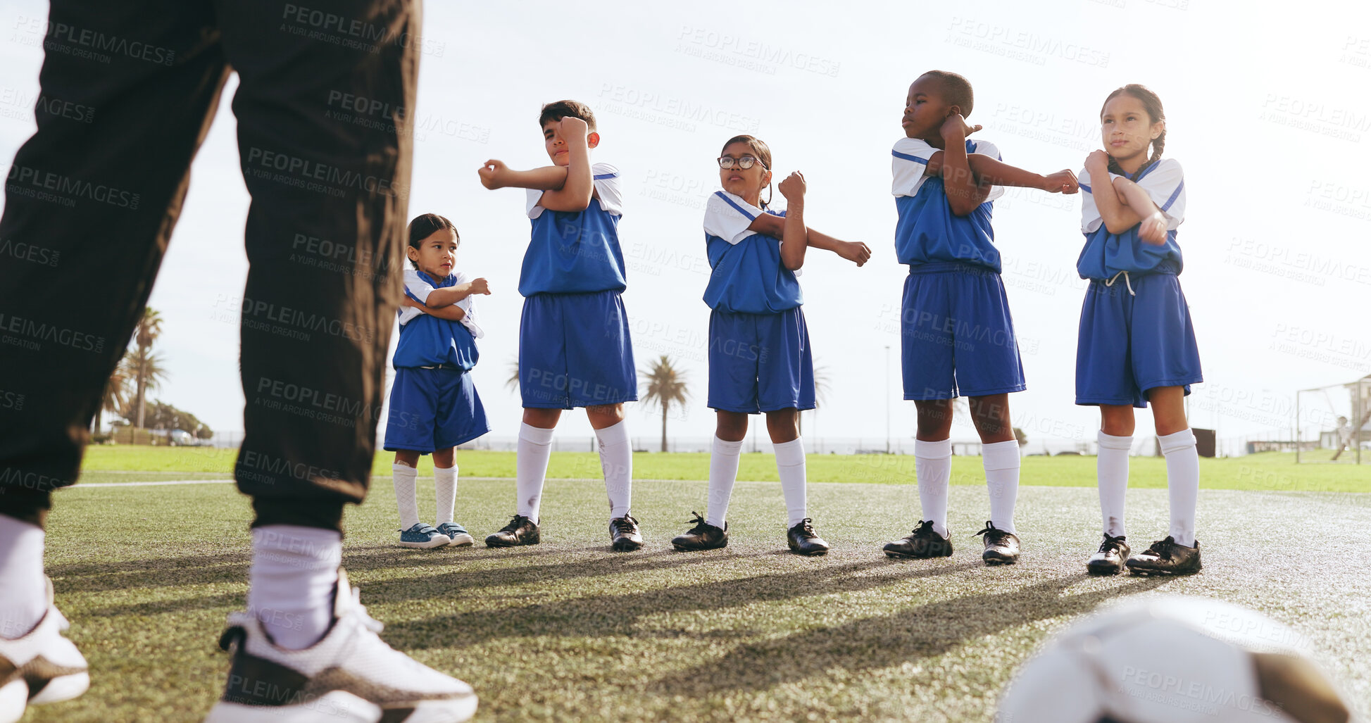 Buy stock photo Coach, kids and stretching on field for soccer, practice and help getting ready for sport game. Trainer, legs and children training for football match with warm up, exercise and athlete group outdoor