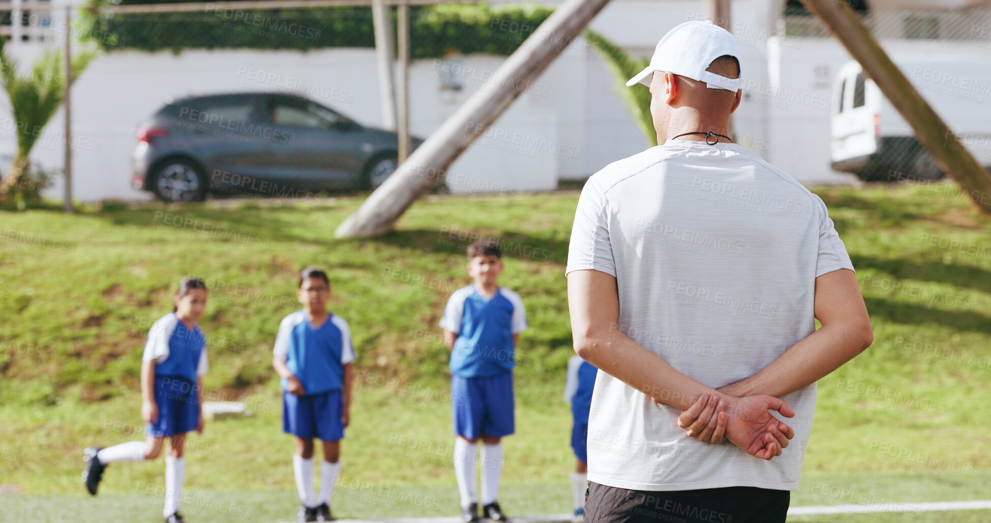 Buy stock photo Outdoor, children or man with coaching for football, sports training or instructions for practice match. Fitness, soccer club or coach with kids team for skill development, field or explain exercise