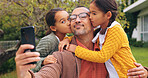 Selfie, kiss and father with children in backyard at home for bonding, love and family time. Happy, connection and girl kids hugging dad for photography picture outdoor for care together on weekend.