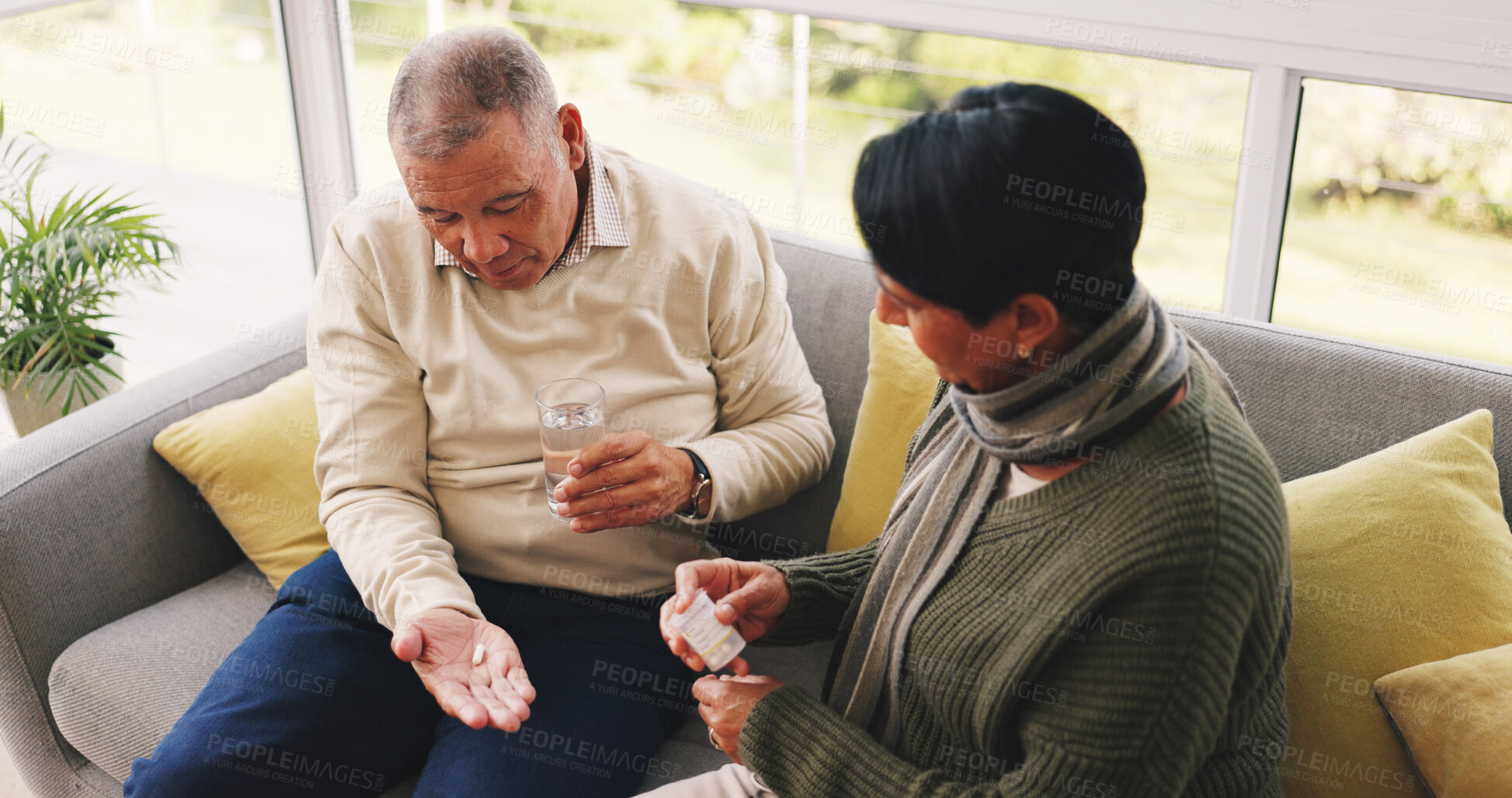 Buy stock photo Pills, water and senior couple on sofa in home with help, care and marriage together on weekend. Health, above and elderly woman with man in living room for vitamins, tablets or medication in house.