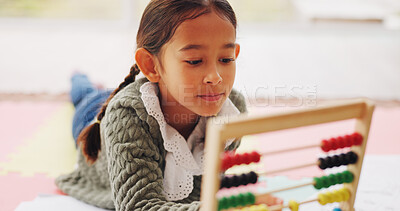 Buy stock photo Child, student and play with abacus in home for education, studying and maths homework. Girl, kid and relax with academic toys for learning addition, calculation solution and numeracy skills on floor