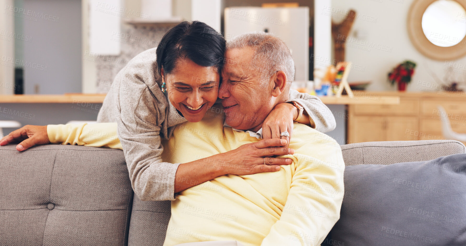 Buy stock photo Happy, hug and senior couple on sofa in home for bonding, marriage or connection on weekend. Smile, love and elderly woman embracing man in living room for trust, safety or care in apartment.
