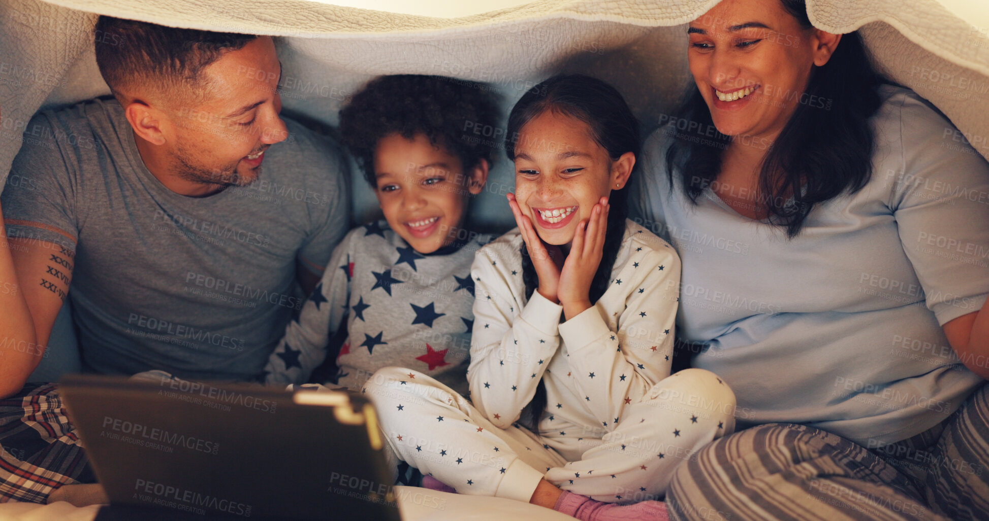 Buy stock photo Tablet, blanket fort and family on bed in home at night with watching movie, film or series on app. Happy, digital technology and parents with children for streaming show online in bedroom at house.