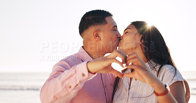 Buy stock photo Heart hands, love and kiss with couple at beach for connection, romance or anniversary getaway. Marriage commitment, summer vacation and trust with man and woman outdoor for support, care and partner