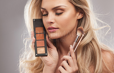 Buy stock photo Woman, makeup and palette with eyeshadow in studio for beauty, color options and makeover glow. Female person, eyes closed and cosmetic brush for facial shine, powder application and white background