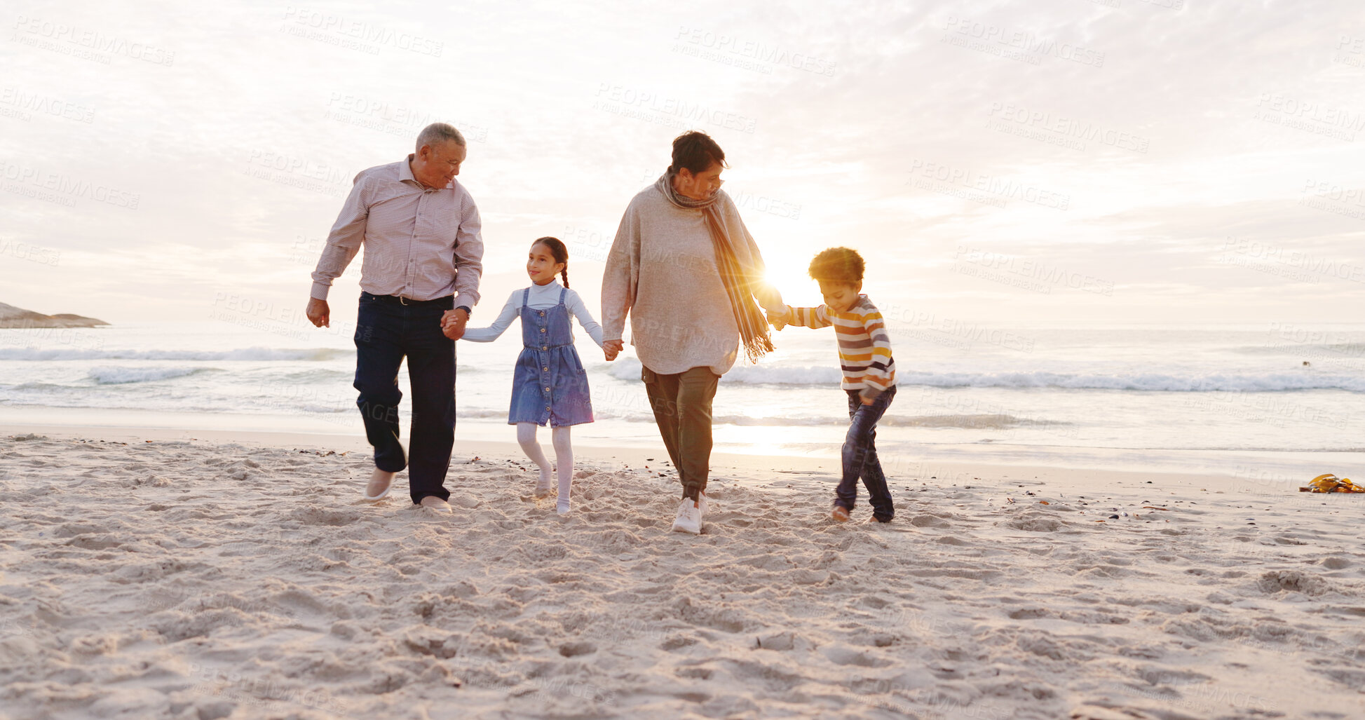 Buy stock photo Happy, walking and grandparents with kids at beach for bonding, love and connection on holiday. Family, holding hands and children with grandma and grandpa for relationship, relax and travel by sea