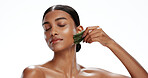 Woman, skincare and massage in studio with gua sha, beauty routine or blood circulation benefits. Person, relax and lymphatic drainage with facial tools, cosmetics or dermatology on white background.
