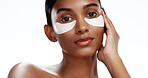 Portrait, woman and eye mask in studio for skincare, dermatology and brightening dark circles. Confident, person and collagen patch for clear skin, wellness and beauty cosmetics on white background.