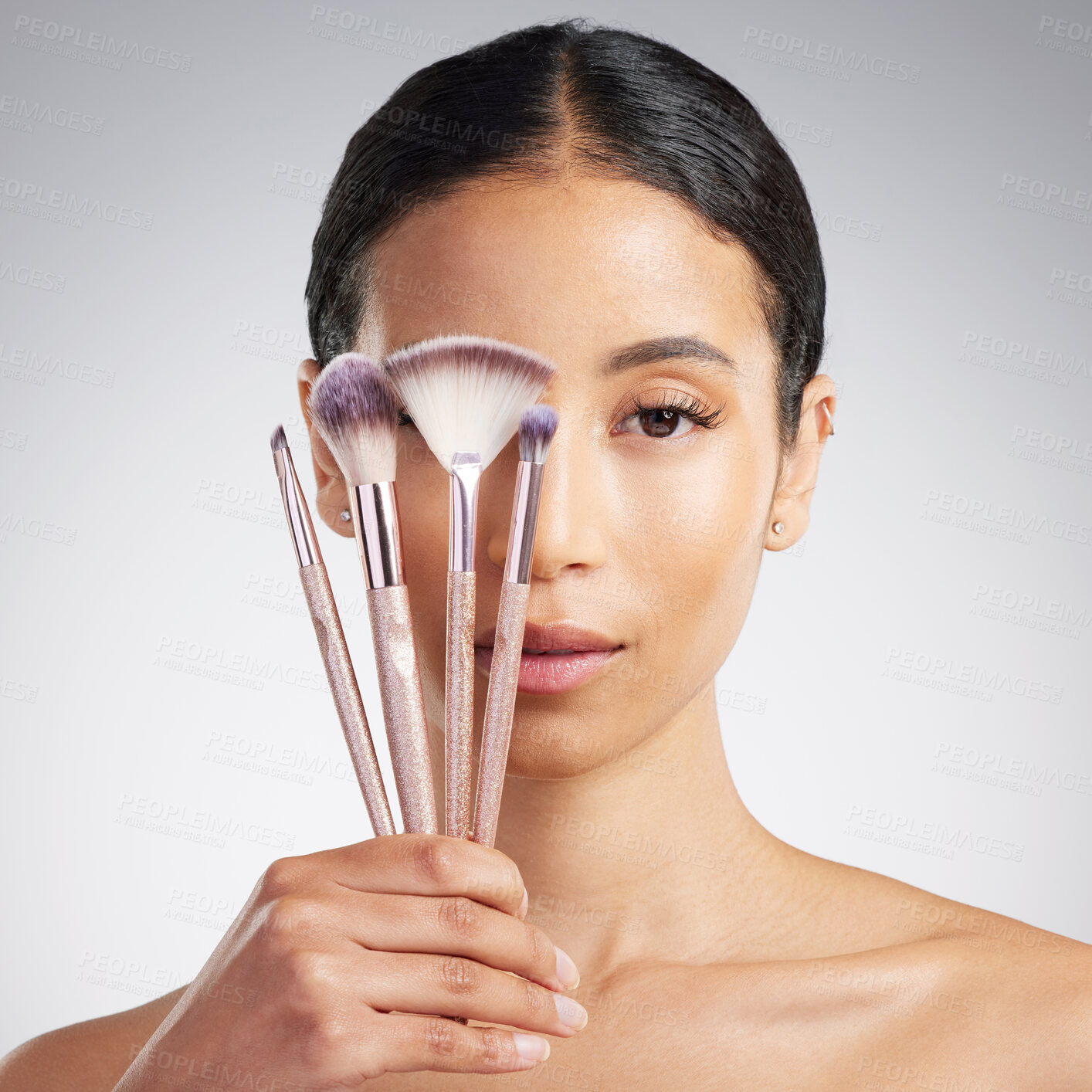 Buy stock photo Brushes, makeup and variety with woman in studio for cosmetics, makeover or transformation. Beauty, portrait and recommend with person on white background for change, facial aesthetic or foundation