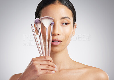 Buy stock photo Beauty, brushes and thinking with woman in studio for cosmetics, makeover or transformation. Decision, makeup and variety with person on white background for change, facial aesthetic or foundation