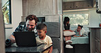 Happy, dad and child on laptop in camper van for nomad living, travel and bonding in mobile home. Family, vehicle and father with boy on computer for online videos, movies and relax on vacation