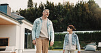 Father, walk and kid at backyard, love and single parent bonding with son for connection together. Outdoor, dad and boy with conversation for care, growth and child development with family support