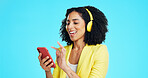 Headphones, phone and businesswoman in studio for music, album or radio with streaming subscription. Happy, audio tech and person with cellphone for listening to playlist on app by blue background.