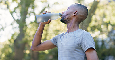 Buy stock photo Fitness, man and drinking water for thirst at park with cardio break, runner recovery and nutrition. Athlete, black person and beverage in nature for exercise electrolytes, hydration or healthy detox