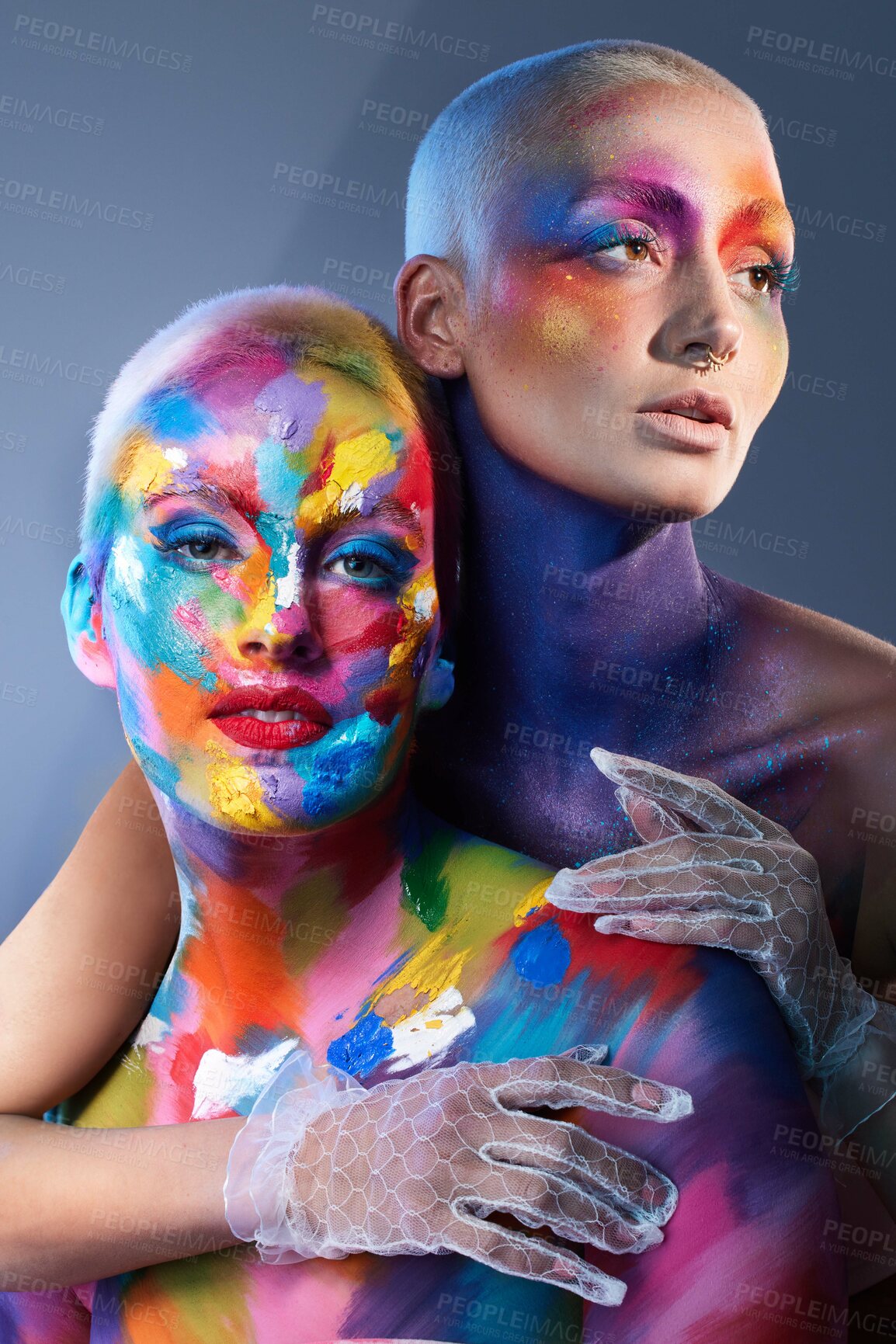 Buy stock photo Creative, people and face paint as makeup in studio for beauty, art deco or aesthetic makeover. Portrait, women and abstract with bold cosmetics for identity, artistic expression and gray background