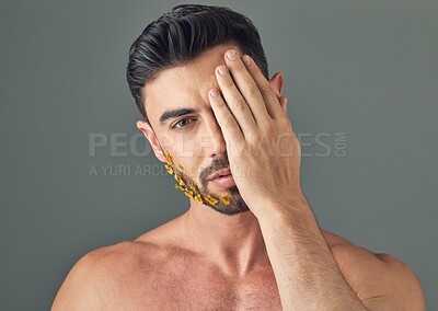 Buy stock photo Studio, man and flowers for beard, beauty and organic treatment for self care on gray background. Floral, facial hair or person with sustainable cosmetics for growth with health, portrait and serious