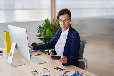 Buy stock photo Creative, computer and business woman with pictures for profile, portfolio and info at modeling agency. Desk, office and mature person with photos for talent scout, casting director or booking shoots