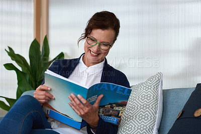 Buy stock photo Happy woman, reading and relax with magazine on sofa with travel review, glasses and article in home. Mature person, publication and story with subscription, smile or break with media in apartment