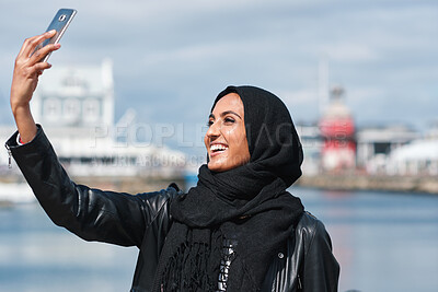 Buy stock photo Muslim woman, selfie and promenade by ocean with smile on vacation, travel and memory at waterfront. Islamic person, space and photography on app, social media and profile picture on seaside holiday