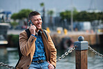 Businessman man using smartphone having phone call talking on mobile phone in waterfront harbour