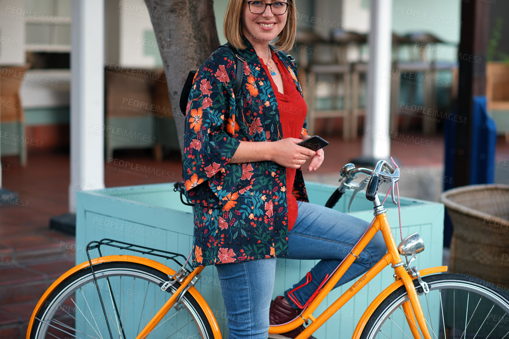 Buy stock photo Happy woman, bicycle and phone in city for travel with glasses, portrait and eco friendly commute. Person, smile and vintage bike with confidence in town, outdoor and sustainable transport in Spain