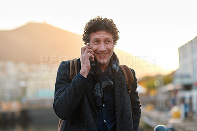 Buy stock photo Man, phone call and business trip in town, travel and contact for taxi, happy and sunset. Mature person, smile and commute with mobile communication, booking ride or waiting for transport in city