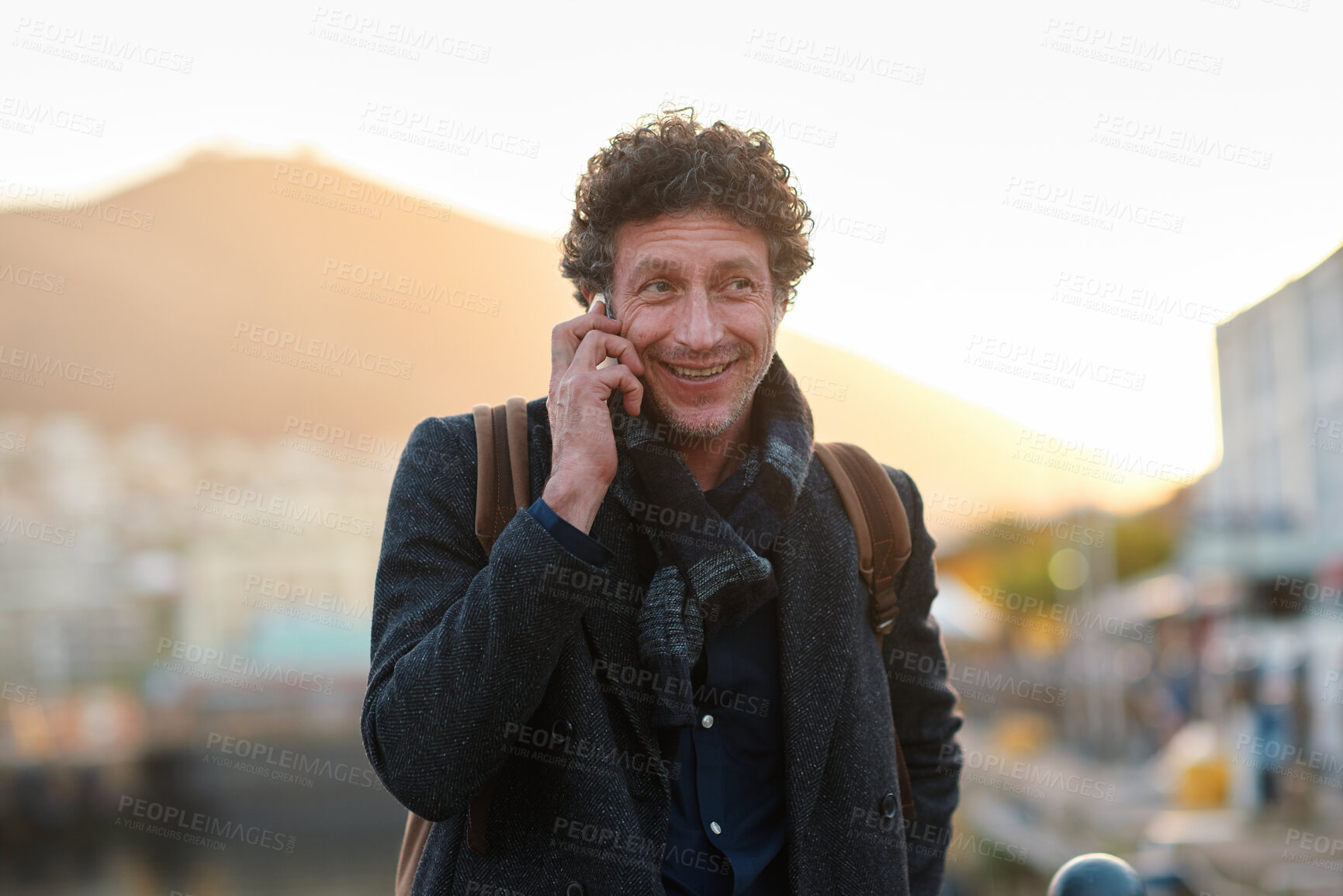 Buy stock photo Man, phone call and business trip in town, travel and contact for taxi, happy and sunset. Mature person, smile and commute with mobile communication, booking ride or waiting for transport in city