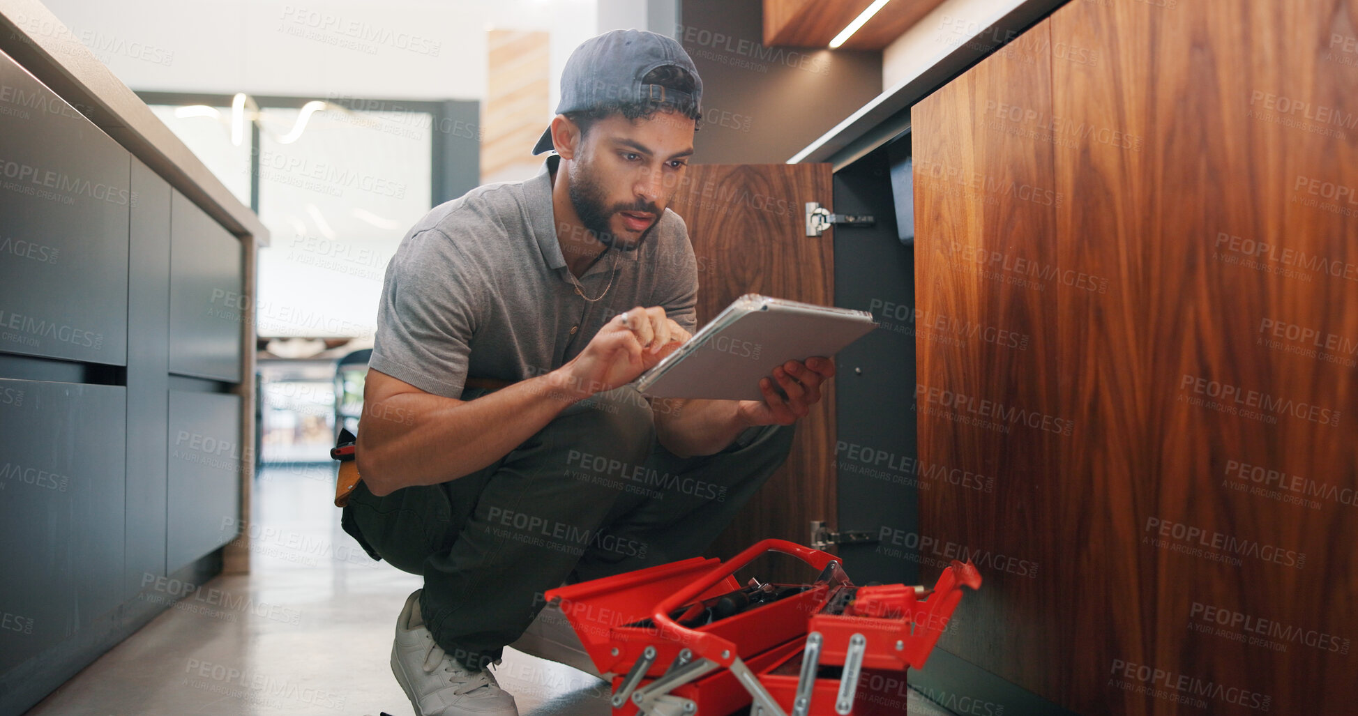 Buy stock photo Plumber, man and maintenance in kitchen with tablet, inspection and review for quality assurance. Handyman, person and scroll in house with tech, plumbing checklist or report for restoration project.