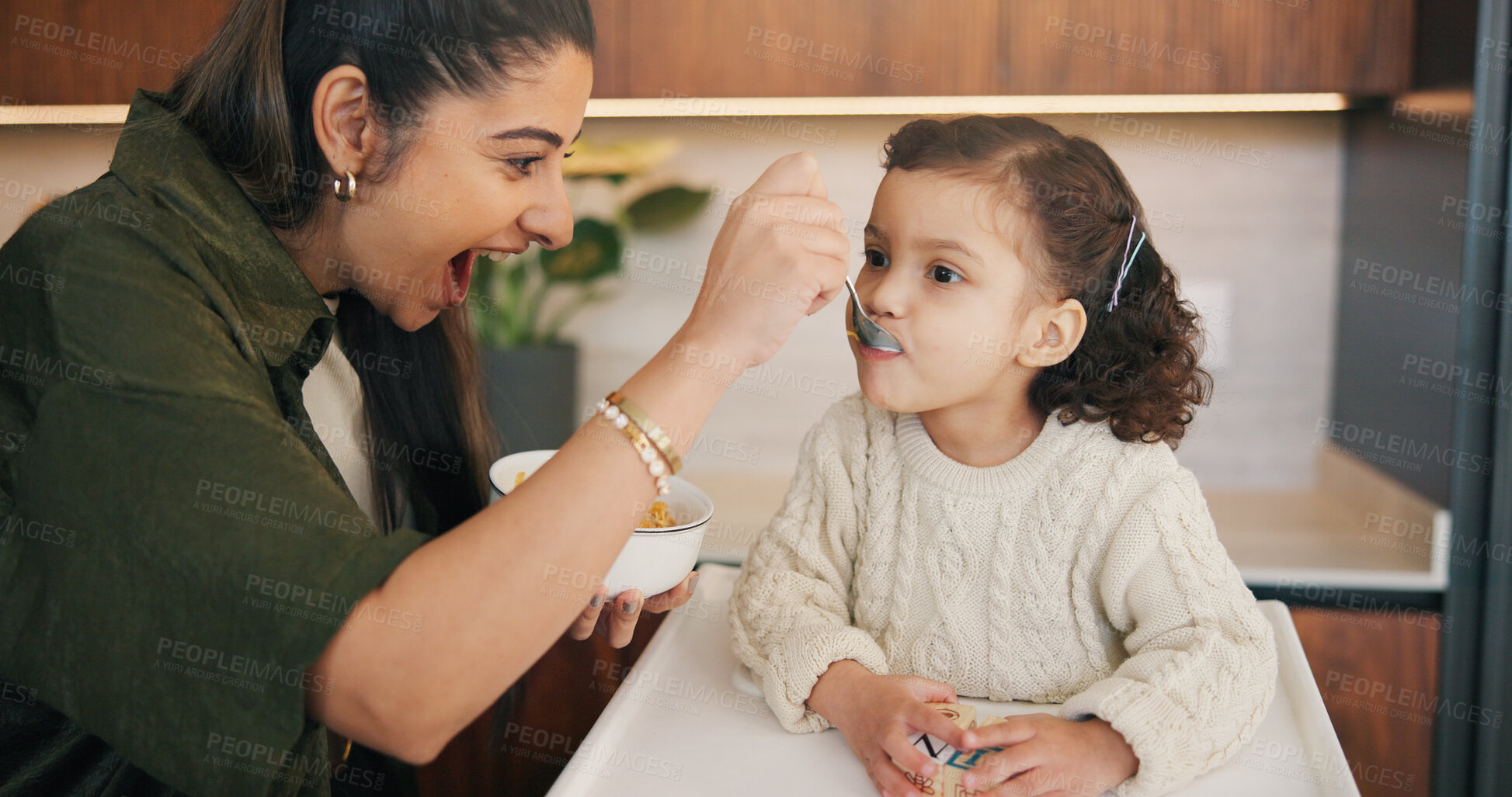 Buy stock photo Mother, child and feeding food in house while excited, happy and support wellness of daughter. Woman, toddler girl and chair for breakfast, nutrition and healthy diet for development, growth and care