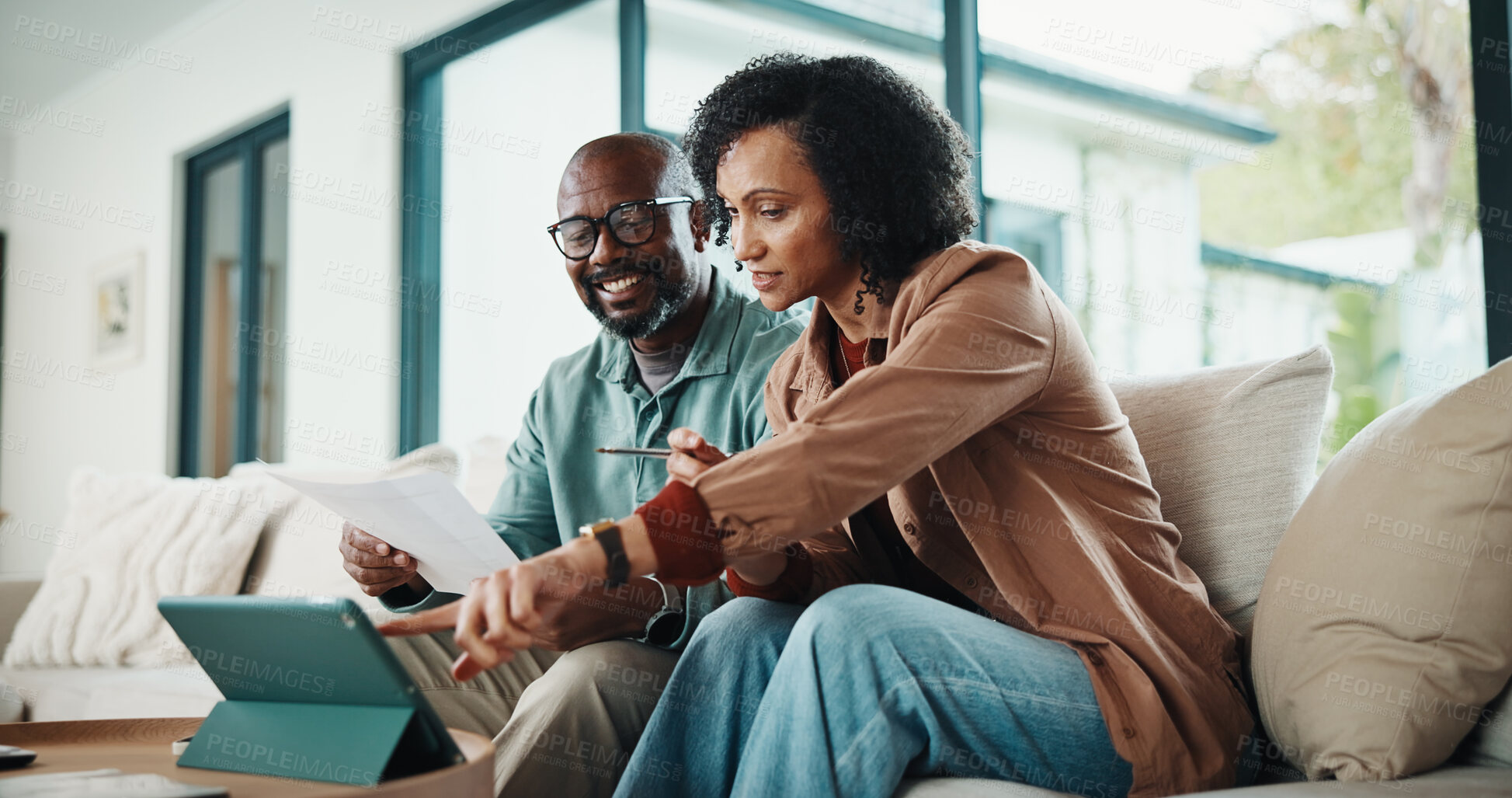 Buy stock photo Paperwork, home and couple with tablet, insurance or asset management for mortgage in living room. African man, mature woman and finance on sofa, policy document and point for investment with tech