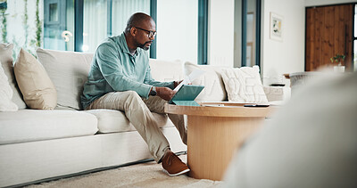 Buy stock photo Paperwork, tablet and black man in home for finance review, budget planning and payment for bills. House, documents and mature person on digital tech for online banking, expenses and financial report