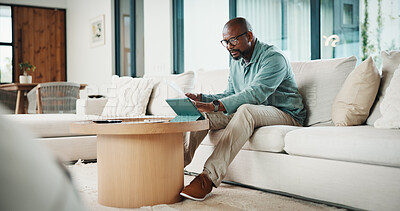 Buy stock photo Documents, tablet and black man on sofa with bills for finance review, budget planning and payment. Home, paperwork and mature person on digital tech for online banking, expenses and financial report