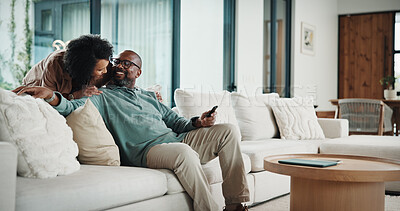 Buy stock photo Happy, couple and watching tv on couch, home and bonding with partner on weekend or streaming movie. Mature people, love and connection with spouse on break, smile and relax together in living room
