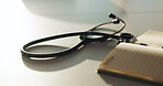 Wellness, notebook and stethoscope on desk in hospital for heartbeat monitor, schedule reminder or medical. Healthcare, cardiology and research with doctors equipment in clinic or empty office