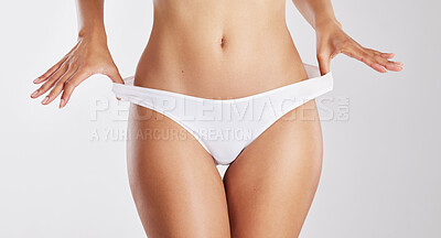 Buy stock photo Hands, diet and panty with stretching in studio for wellness, transformation or underwear on white background. Person, stomach and self care with change, dermatology and healthy body with weight loss